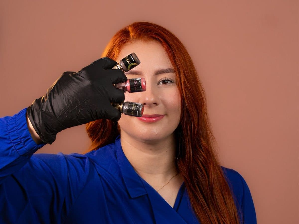 Xiomara mostrando pigmentos utilizados en la formación profesional de cejas